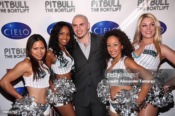 Rapper Pitbull poses with the Florida Marlins Mermaids at Cielo Garden & Supperclub during the launch party for Pitbull's Imaginate Foundation on...