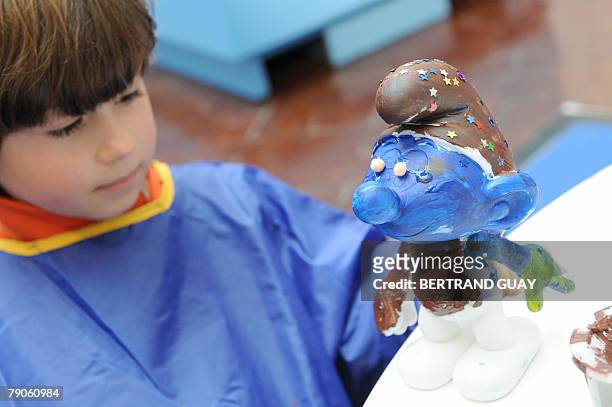 Grandes schtroumpferies pr?vues pour le 50?me anniversaire des Schtroumpfs". A child paints a figurine during the celebration of the 50th anniversary...