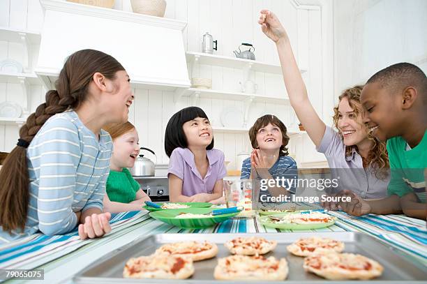 enfants faisant des pizzas - femme bras tendu cuillère photos et images de collection