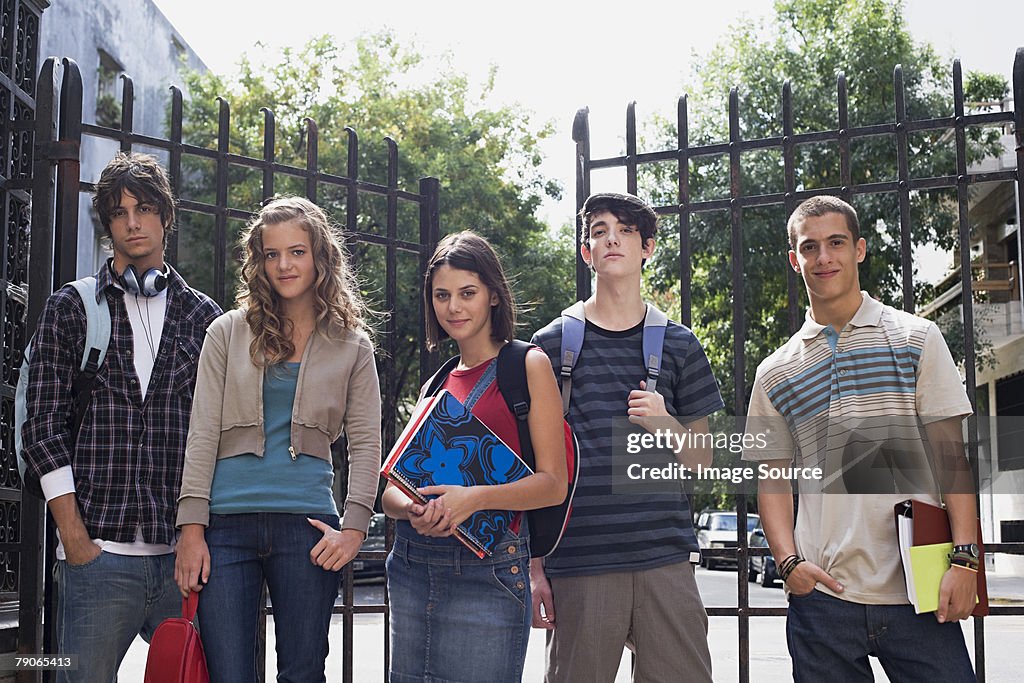 Teenagers standing near metal gates