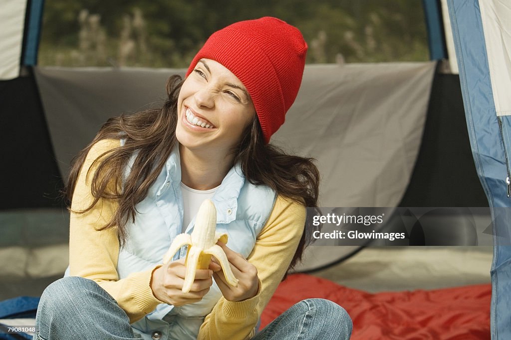 Close-up of a young woman peeling a banana