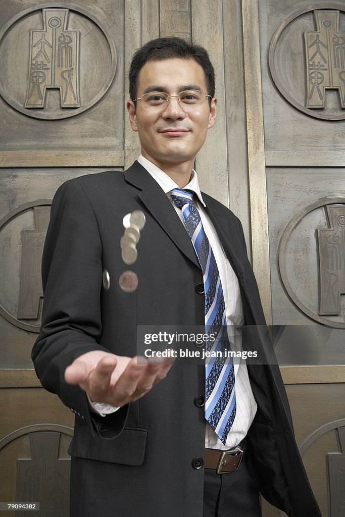 A business man throwing coins.