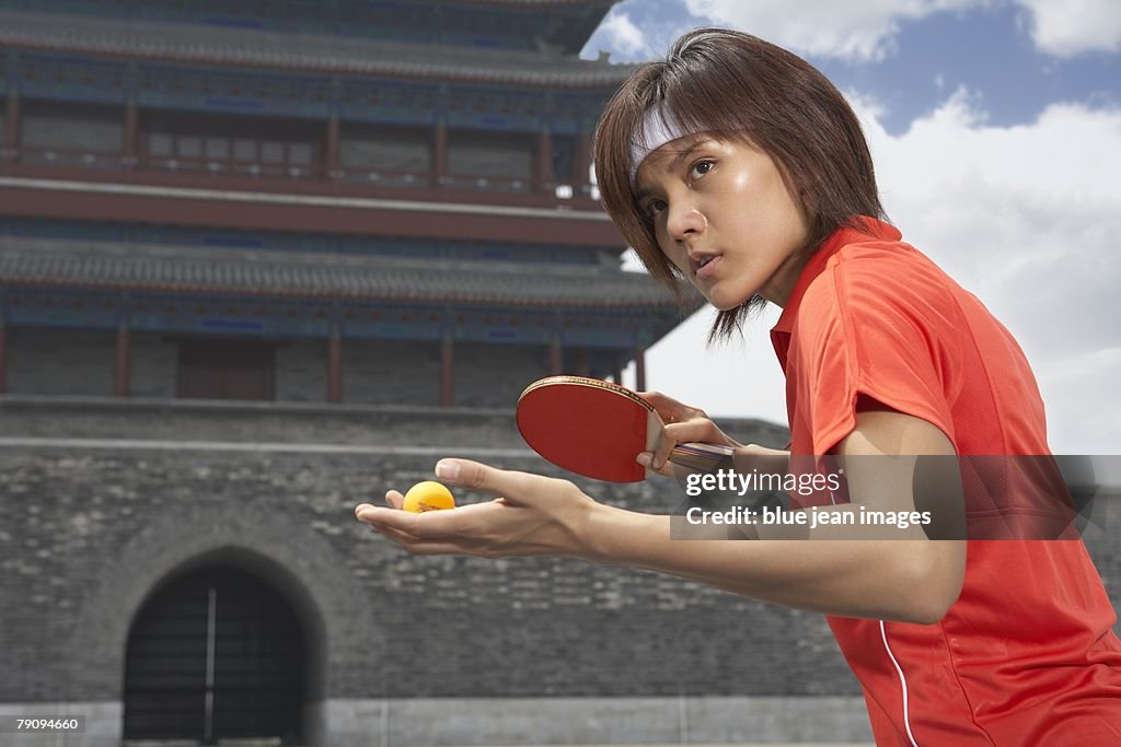 Every point counts. An athlete playing table tennis in front of an ancient Chinese building.