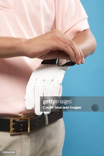 a golfer adjusting his glove. - golfhandschuh stock-fotos und bilder