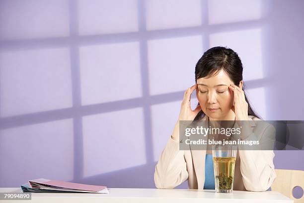 taking a time out. a businesswoman with her eyes closed. - purple tee shirt stock-fotos und bilder