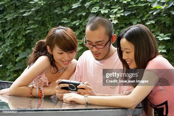 three young people enjoying a computer game. - mobile sculpture fotografías e imágenes de stock