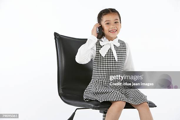 a young girl dressed in business attire making a call on her cell phone. - stereotypically upper class stock pictures, royalty-free photos & images
