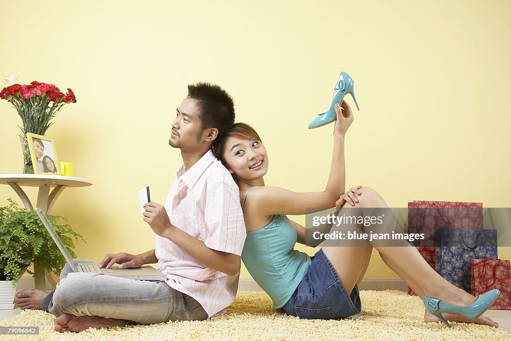 A young man considers his next online purchase, while a young woman shows off her new shoes.