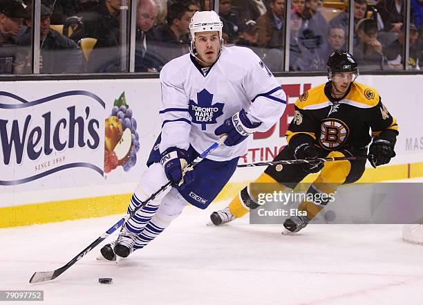 Ian White of the Toronto Maple Leafs takes the puck as David Krejci of the Boston Bruins defends on January 17, 2008 at the TD Banknorth Garden in...