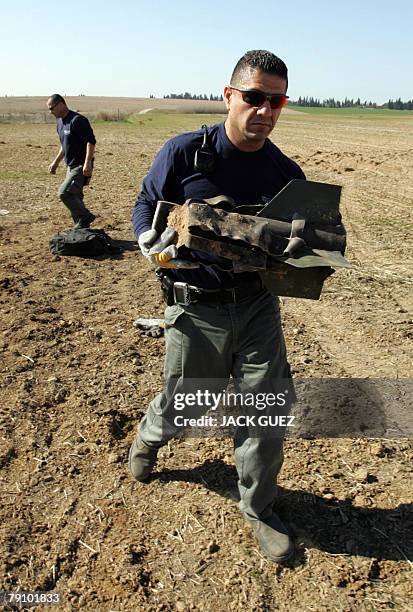 Israeli police bomb squad officers remove the remains of a rocket fired from the Gaza Strip and which struck a field in the southern Israeli city of...