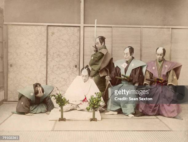 Staged version of the Japanese ritual suicide known as Seppuku or Hara-Kiri, circa 1885. The warrior in white plunges a knife into his belly, while...