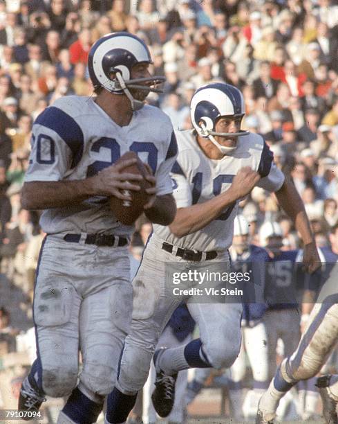 Running back Tommy Mason of the Los Angeles Rams rolls out to pass as quarterback Roman Gabriel runs to block against the Baltimore Colts at the Los...