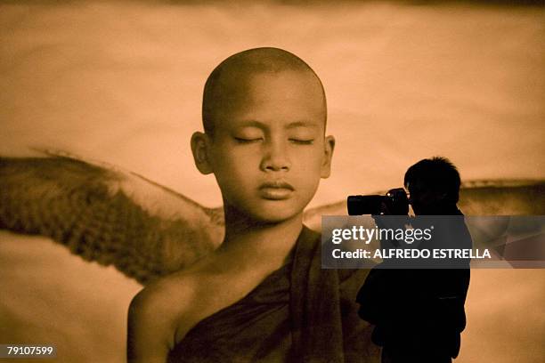 Photographer takes a picture in front of an image by Canadian photographer Gregory Colbert, during the opening of his exhibition called "Ashes and...