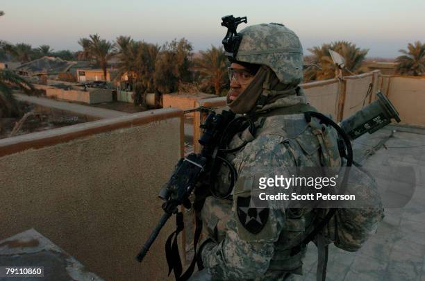 Sgt. Dennis Jill of Santa Rosa, California, stands guard on a rooftop while U.S. Army soldiers of Troop A, 2nd Squadron, 1st Cavalry Regiment search...