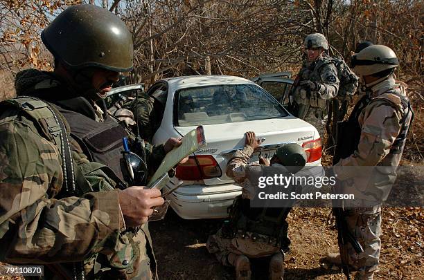 Iraqi Army and U.S. Army soldiers of Troop A, 2nd Squadron, 1st Cavalry Regiment find an Al Qaeda in Iraq expense ledger in a car before blowing it...