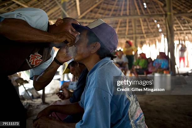 Man blows smoke in the villages elders faces after smoking and inhaling a small branche called "War Suid" The five village elders, or "Inn Sobed",...