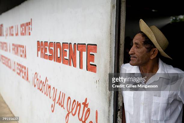 Man wearing a traditional "campesino" or Panamean farmer hat watches the day go by at the entrance of a pool bar in a small town on the Panamamerican...