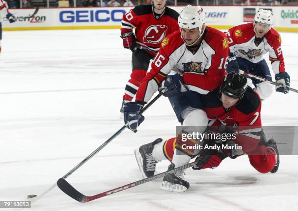 Nathan Horton of the Florida Panthers plays the puck while being checked by Paul Martin of the New Jersey Devils during a game at the Prudential...