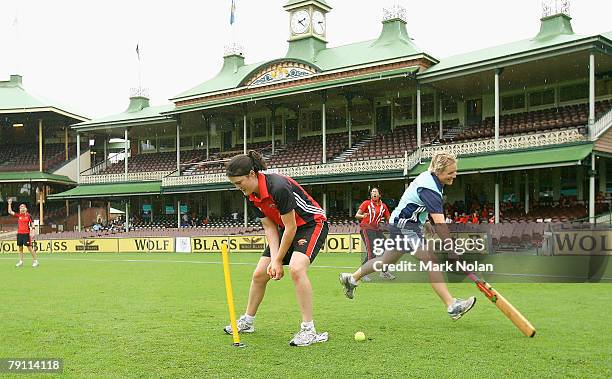 South Australian and NSW players play cricket in the rain on the outfield waiting for the rain to clear during the WNCL final between the NSW...