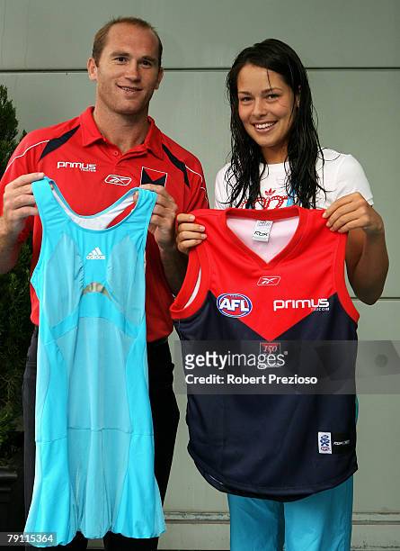 Melbourne Demon AFL player David Neitz and Ana Ivanovic of Serbia hold up each others sporting attire offcourt on day six of the Australian Open 2008...