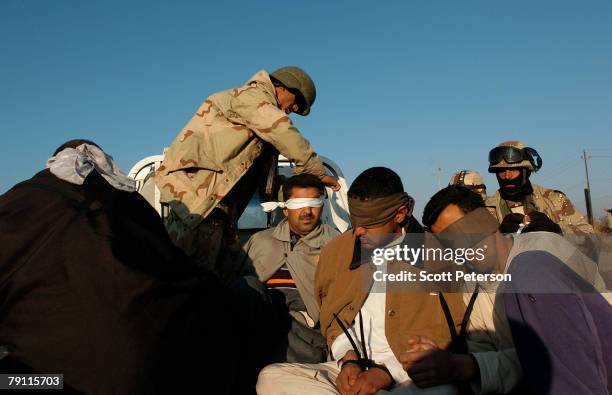 Iraqi troops take control of detainees while US Army soldiers search for Al Qaeda militants in the Diyala River village of Hussein al-Hamadi, 20...