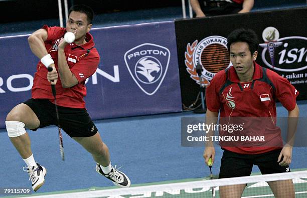 Indonesia's mens doubles pair Markis Kido smashes as Hendra Setiawan looks on as they challenge doubles pair Indonesian Candra Wijaya and US shuttler...