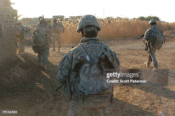 Army soldiers of Troop A, 2nd Squadron, 1st Cavalry Regiment search for Al Qaeda militants in the Diyala River village of Dulim, 20 miles northeast...