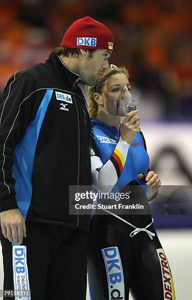 Anni Friesinger of Germany breaths some oxygen as she is congratulated by husband Gianni Romme after winning the ladies 1000m race during the first...