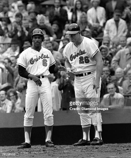 Outfielder Paul Blair and firstbaseman Boog Powell of the Baltimore Orioles talk with each other while waiting for Frank Robinson to circle the bases...