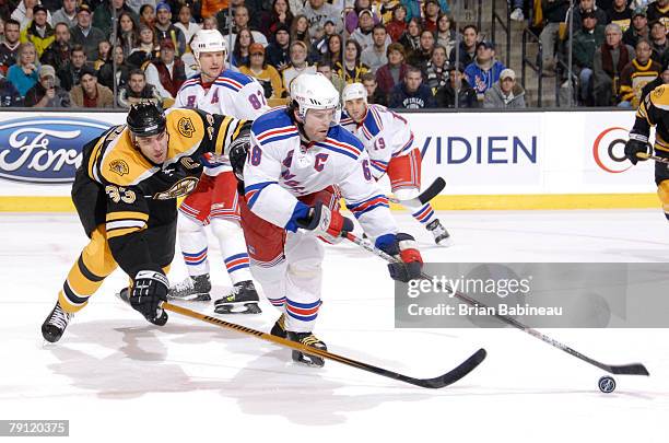 Zdeno Chara of the Boston Bruins fights for the puck against Jaromir Jagr of the New York Rangers at the TD Banknorth Garden on January 19, 2008 in...