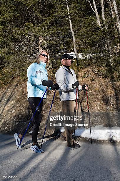 couple walking with poles - hiking pole stock pictures, royalty-free photos & images