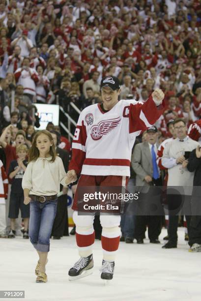 Captain Steve Yzerman of the Detroit Red Wings celebrates as he skates to center ice with his daughter Isabella for the presentation of the Stanley...