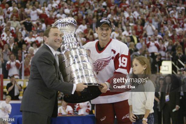Commisioner Gary Bettman presents the Stanley Cup to captain Steve Yzerman of the Detroit Red Wings with his daughter Isabella after eliminating the...
