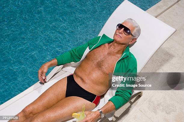 alter mann entspannend am pool - beach lounger stock-fotos und bilder