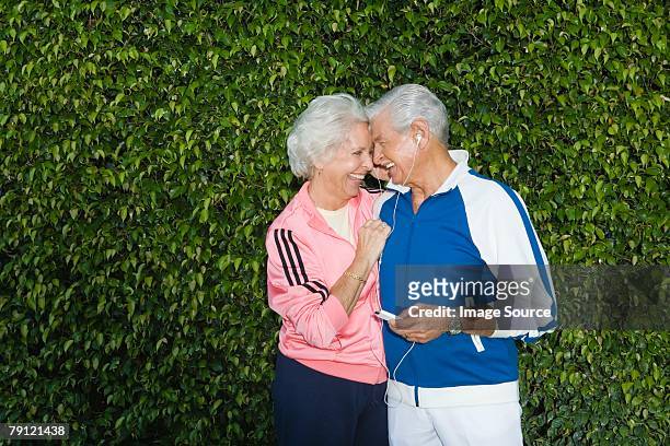 couple listening to mp3 player - hedge fonds stock pictures, royalty-free photos & images