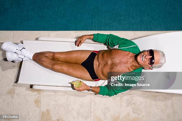 man relaxing by pool - zwembroek stockfoto's en -beelden