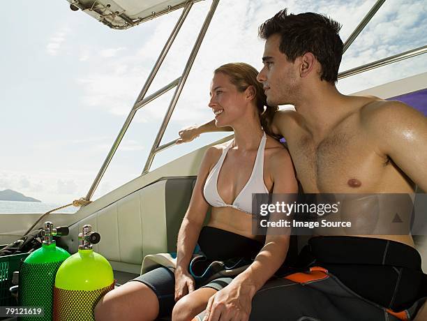 couple in a boat - wetsuit stock pictures, royalty-free photos & images