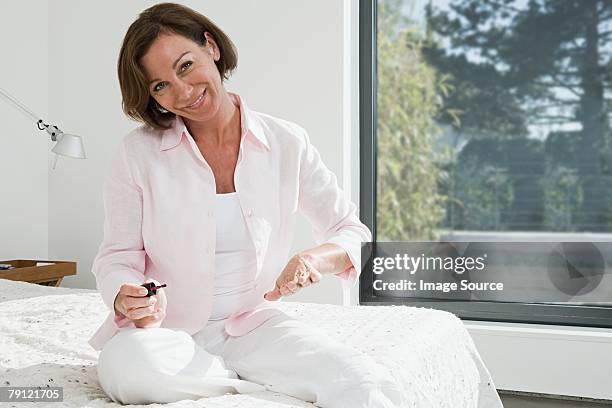 frau malt ihre fingernägel - lackierte-fingernägel-finger stock-fotos und bilder