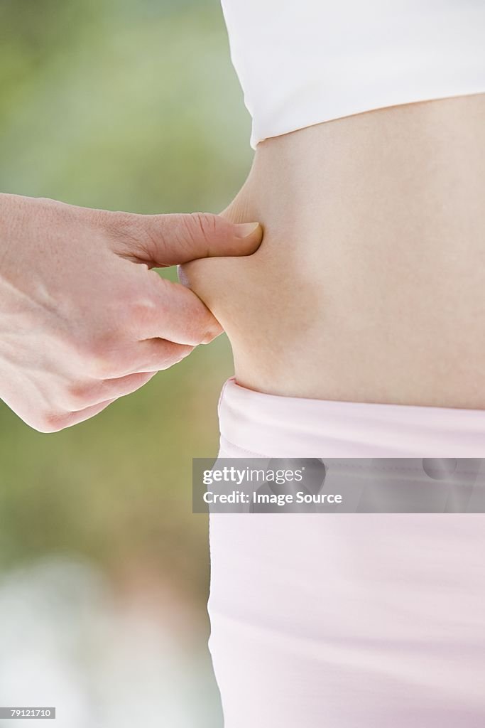 Woman pinching her stomach