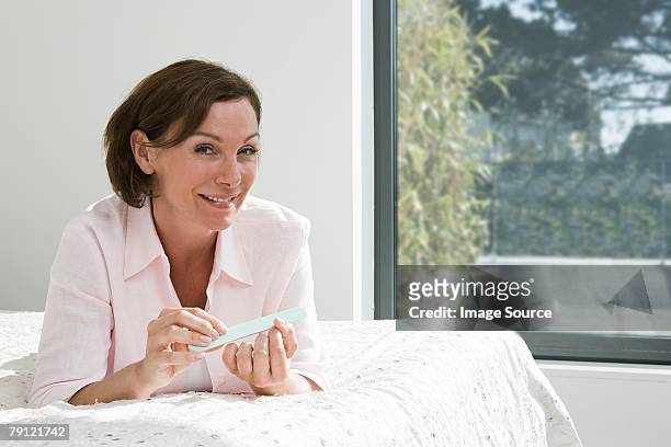 woman filing her nails - nail file stock pictures, royalty-free photos & images
