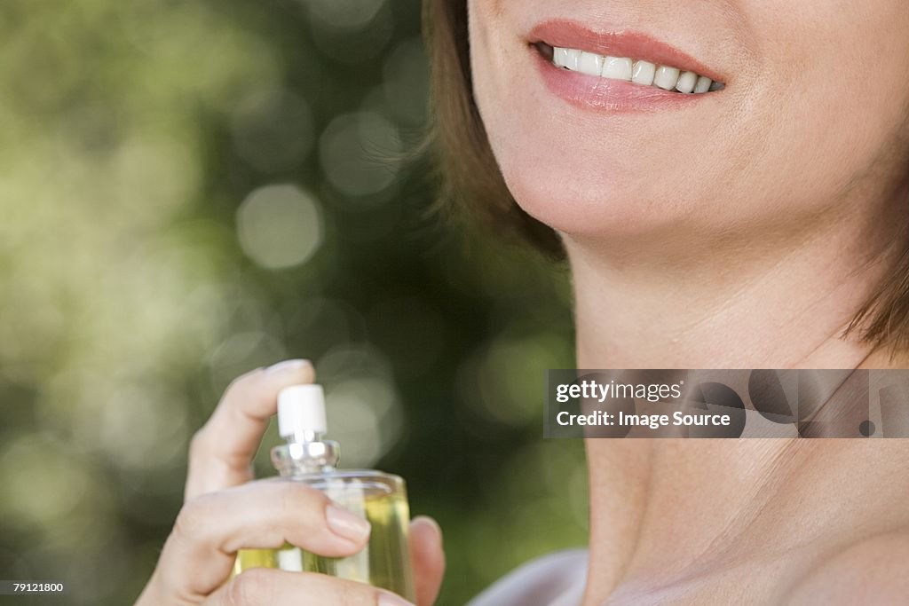 Donna di spruzzare profumo sul collo