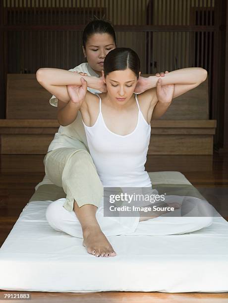 young woman having a thai massage - thai culture stock pictures, royalty-free photos & images