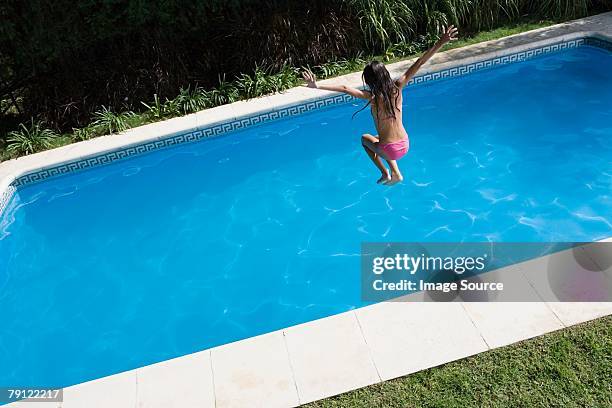 girl jumping into swimming pool - cannon ball pool stock pictures, royalty-free photos & images