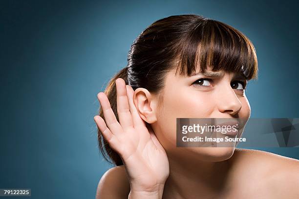 woman putting hand to her ear - ear stock pictures, royalty-free photos & images