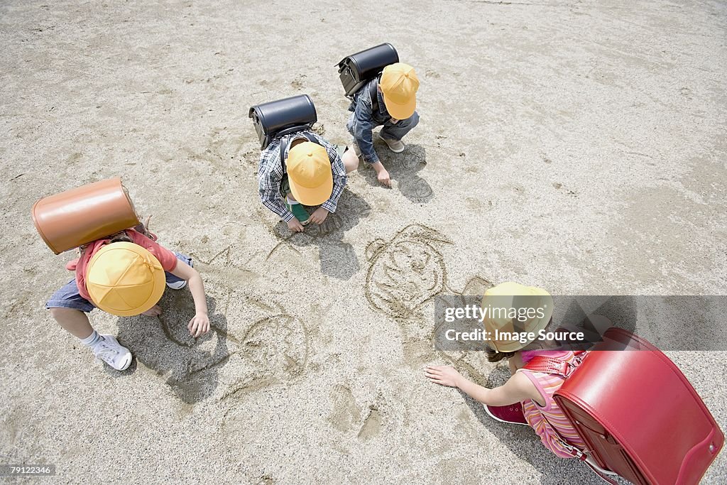 Children drawing in the sand