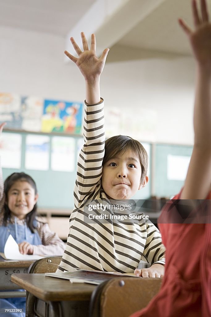 A boy with his hand raised