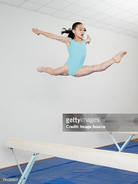 girl jumping above balance beam - doing the splits stock pictures, royalty-free photos & images