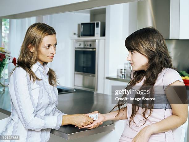 mother giving condom to daughter - condoms stock pictures, royalty-free photos & images