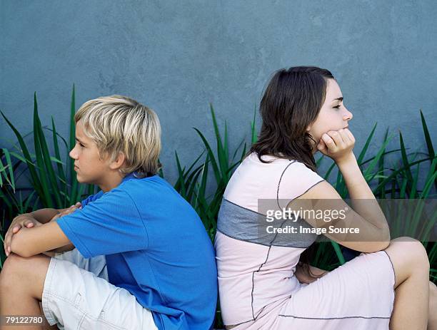 brother and sister back to back - teenager arguing stock pictures, royalty-free photos & images