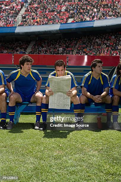 footballer leer un periódico - subs bench fotografías e imágenes de stock